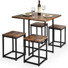 a table with four stools next to a bottle of wine and two empty glasses