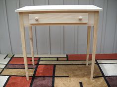 a small wooden table sitting on top of a rug