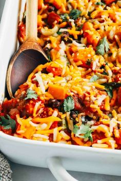 a casserole dish filled with mexican food and garnished with cilantro