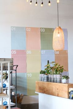 the interior of a coffee shop with colorful tiles on the wall and potted plants