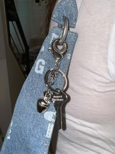 a woman wearing a jean belt with a heart shaped keychain attached to it