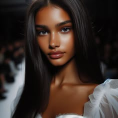 a woman with long dark hair wearing a white dress