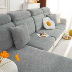 a living room with a gray couch and yellow flowers