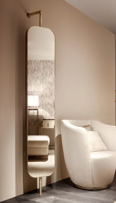 a white chair sitting next to a tall mirror in a living room filled with furniture