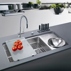 a kitchen sink that has some tomatoes on it