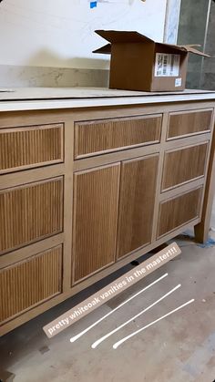 an unfinished dresser is being built in the process of being painted with paint and tape