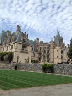 a large building with lots of windows on the side of it and green grass in front of it