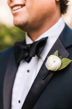 a man in a tuxedo with a white flower on his lapel pin