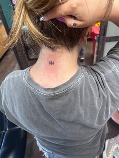 a woman with a small tattoo on her neck