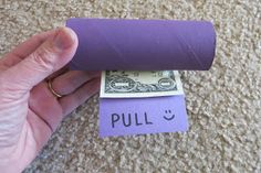 a roll of purple paper with the word pull on it next to a hundred dollar bill