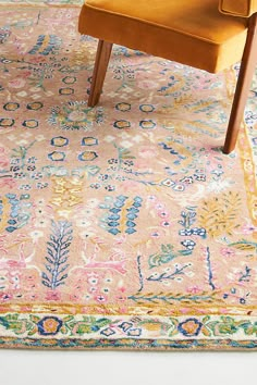 an orange chair sitting on top of a colorful rug