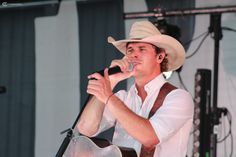 a man in a cowboy hat singing into a microphone