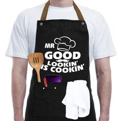 a man wearing an apron and cooking utensils in front of his shirt that says, mr good looking is cookin '