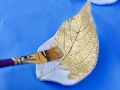 a leaf with a brush on it sitting on top of a blue cloth covered table