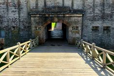 a wooden bridge leading to an old brick building