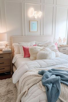 a white bed with pillows and blankets on it