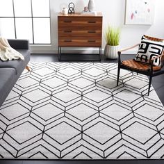 a living room with a gray couch and white rug