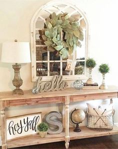 a wooden table topped with a mirror next to a lamp and potted plant on top of it