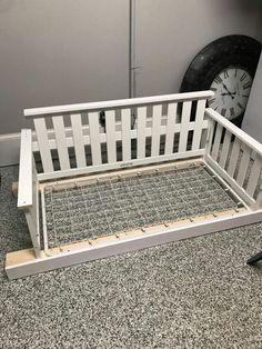 a white bench sitting on top of a floor next to a clock