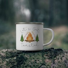 a campfire mug with the words let's go fantastic on it sitting on top of a tree stump