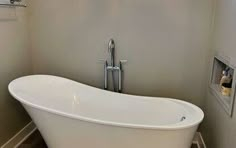 a white bath tub sitting inside of a bathroom