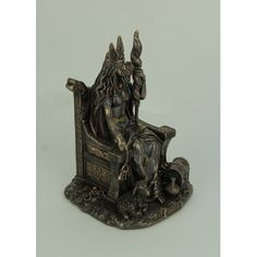 a statue of an egyptian god sitting on a throne with his hands in the air