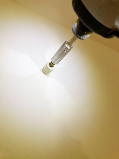 a light that is on top of a white table with a screwdriver in it