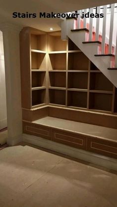 an empty room with stairs and built in bookshelves