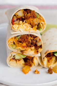 three burritos stacked on top of each other with meat, cheese and vegetables