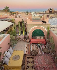 an outdoor living area with couches, rugs and potted plants on the roof