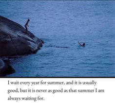 two people swimming in the water near a large rock with a poem written on it