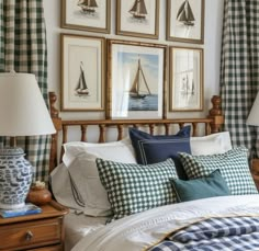 a bed with blue and white pillows in front of pictures on the wall above it