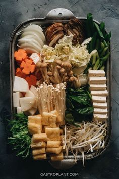 a bento box filled with different types of vegetables and tofus on top of each other