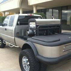 a large truck parked in front of a building with its hood up and flatbed