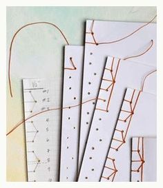 four pieces of paper with orange thread on them