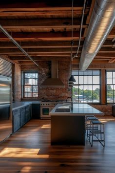 an industrial style kitchen with wooden floors and exposed ceilings, along with stainless steel appliances