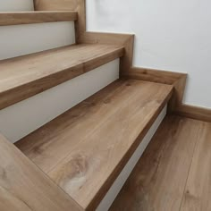 some wooden stairs with white walls and wood flooring