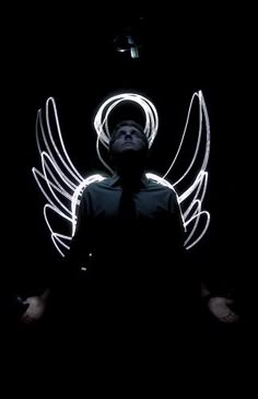 a man standing in the dark with angel wings