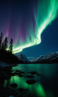 an aurora bore is seen over a lake in the mountains