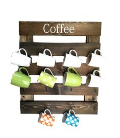 a wooden rack with cups and mugs hanging from it's sides on the wall