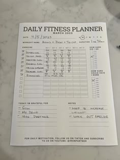 a daily fitness planner on a marble counter top