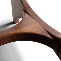 a close up of a wooden chair with curved arms and wood grained backrests