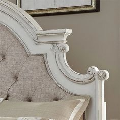 a white bed with an ornate headboard and foot board