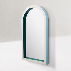 a white and blue arched mirror on the wall