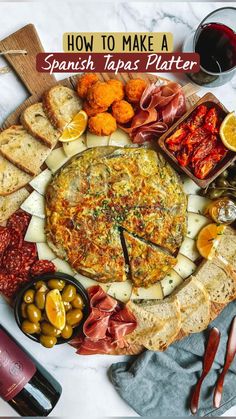 a platter with cheese, meats and bread on it next to wine glasses