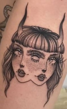 a woman's face with horns on her head is shown in this tattoo design