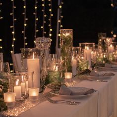 the table is set with candles, plates and napkins for an elegant dinner party