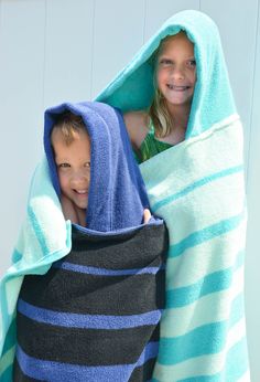 two children wrapped up in towels and smiling