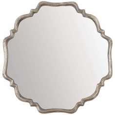 an ornate silver mirror on a white wall