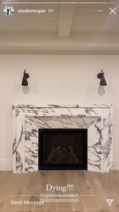 an empty room with a fireplace and two black lamps on the wall next to it